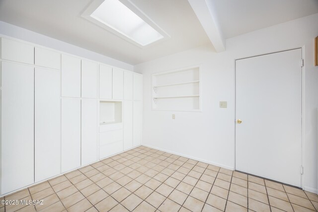 5449 E Rosewood St, Tucson, AZ 85711 - spare room with built in shelves and beam ceiling