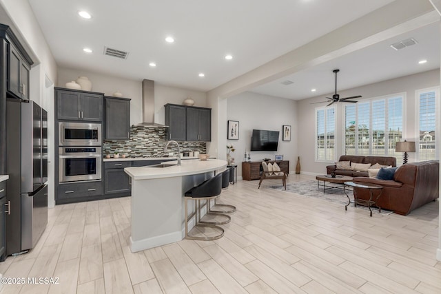 1936 N Star Vw Ln, Green Valley, AZ 85614 - kitchen featuring appliances with stainless steel finishes, wall chimney range hood, open floor plan, light countertops, and decorative backsplash