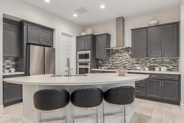 1936 N Star Vw Ln, Green Valley, AZ 85614 - kitchen with wall chimney range hood, appliances with stainless steel finishes, a sink, a breakfast bar, and light countertops