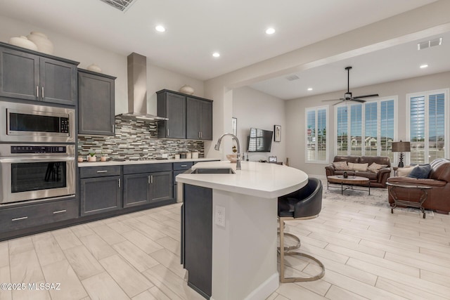 1936 N Star Vw Ln, Green Valley, AZ 85614 - kitchen with stainless steel appliances, wall chimney range hood, a sink, light countertops, and backsplash