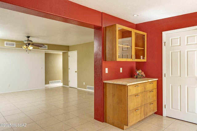 3600 N Hash Knife Cir, Tucson, AZ 85749 - kitchen with light tile patterned flooring, a ceiling fan, light countertops, baseboards, and glass insert cabinets