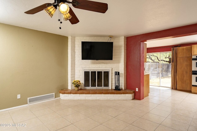 3600 N Hash Knife Cir, Tucson, AZ 85749 - unfurnished living room with ceiling fan, a fireplace, and light tile patterned floors