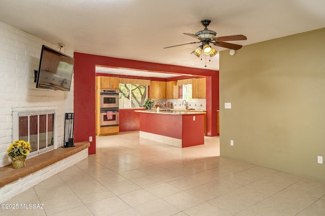 3600 N Hash Knife Cir, Tucson, AZ 85749 - unfurnished living room featuring a sink, a fireplace, ceiling fan, and light tile patterned floors