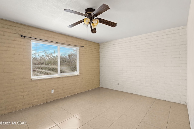 3600 N Hash Knife Cir, Tucson, AZ 85749 - empty room with brick wall, a ceiling fan, and light tile patterned flooring