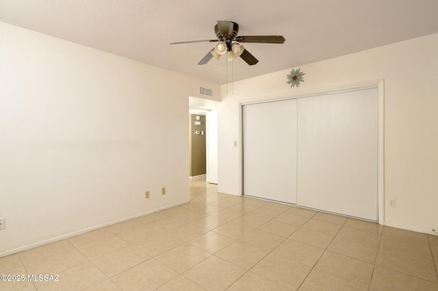 3600 N Hash Knife Cir, Tucson, AZ 85749 - unfurnished bedroom with a closet, ceiling fan, and light tile patterned flooring