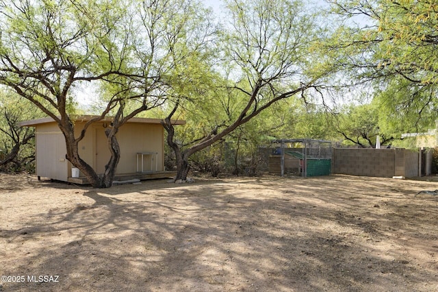 3600 N Hash Knife Cir, Tucson, AZ 85749 - view of yard with an outdoor structure, fence, and a storage shed