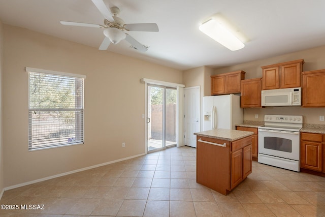 15815 S Via Cayetano, Sahuarita, AZ 85629 - kitchen featuring white appliances, light countertops, a center island, and brown cabinets