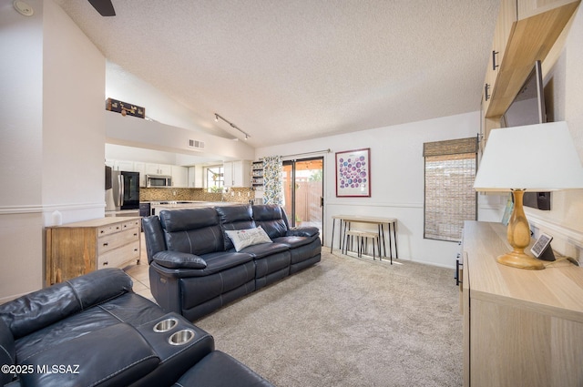 2804 W Camino Ebano, Tucson, AZ 85742 - living room with a textured ceiling, vaulted ceiling, and light carpet