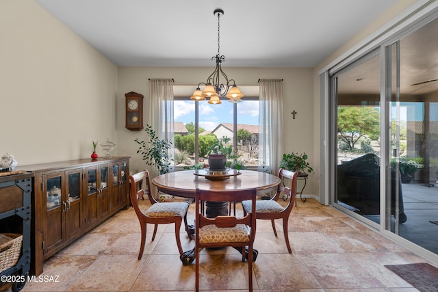 59962 E Arroyo Grande Dr, Oracle, AZ 85623 - dining space featuring stone tile floors, a chandelier, and baseboards