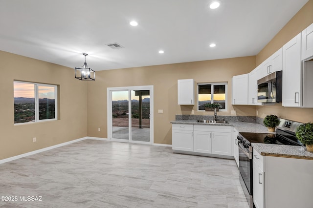 174 Via Casa, Rio Rico, AZ 85648 - kitchen with stainless steel appliances, a sink, light stone counters, white cabinetry, and recessed lighting