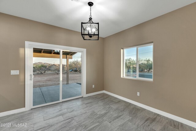 174 Via Casa, Rio Rico, AZ 85648 - spare room with plenty of natural light, a chandelier, and baseboards