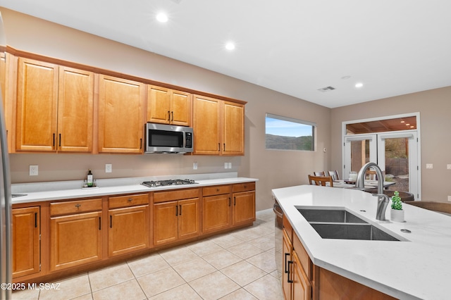 8183 N Sombrero Point Dr, Tucson, AZ 85743 - kitchen featuring appliances with stainless steel finishes, light countertops, light tile patterned floors, brown cabinetry, and recessed lighting