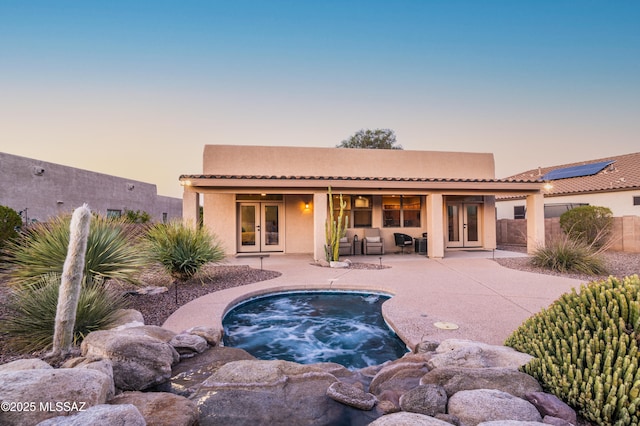 8183 N Sombrero Point Dr, Tucson, AZ 85743 - rear view of house with french doors, an in-ground hot tub, stucco siding, and a patio area