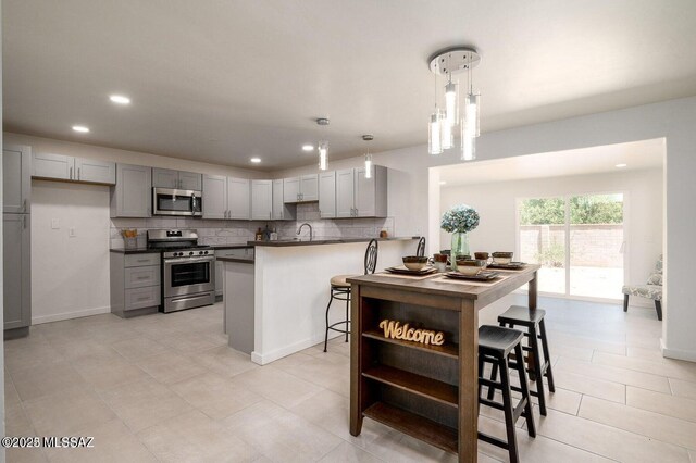 3409 E Linden St, Tucson, AZ 85716 - kitchen featuring stainless steel appliances, gray cabinets, dark countertops, backsplash, and recessed lighting