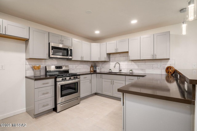 3409 E Linden St, Tucson, AZ 85716 - kitchen featuring appliances with stainless steel finishes, dark countertops, a sink, backsplash, and light tile patterned floors