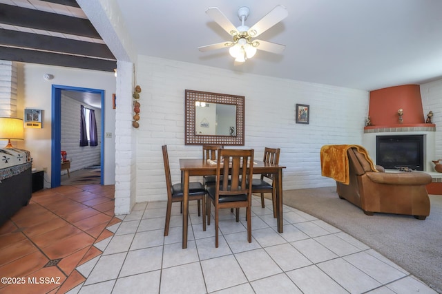 628 Corpino De Pecho, Green Valley, AZ 85614 - dining space featuring brick wall, light tile patterned flooring, a ceiling fan, and a glass covered fireplace