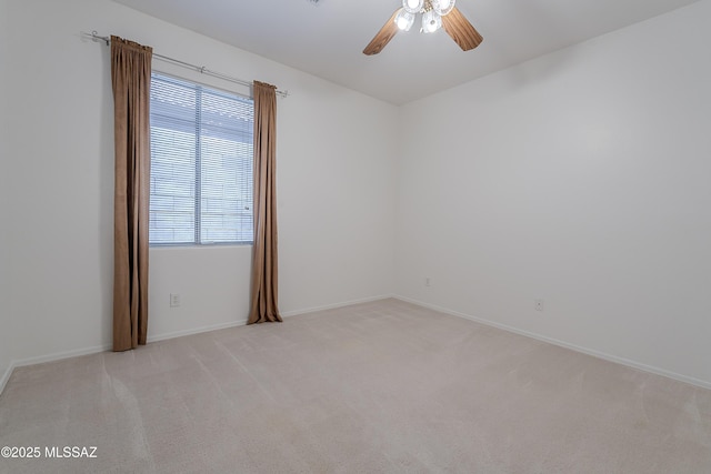 5590 W Acacia Blossom Pl, Marana, AZ 85658 - spare room featuring a ceiling fan, light colored carpet, and baseboards