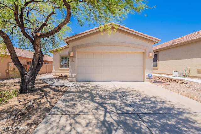 5590 W Acacia Blossom Pl, Marana, AZ 85658 - mediterranean / spanish-style home featuring concrete driveway, an attached garage, stucco siding, and a tile roof