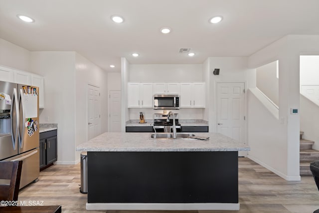 6494 E Brushback Loop, Tucson, AZ 85756 - kitchen featuring stainless steel appliances, light wood-style flooring, white cabinets, baseboards, and recessed lighting