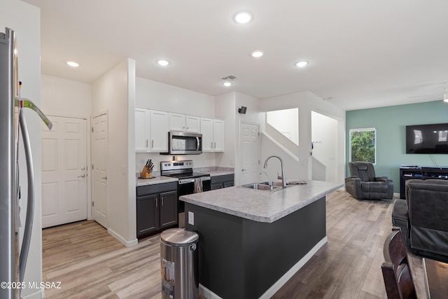 6494 E Brushback Loop, Tucson, AZ 85756 - kitchen featuring stainless steel appliances, open floor plan, a sink, light wood-type flooring, and recessed lighting