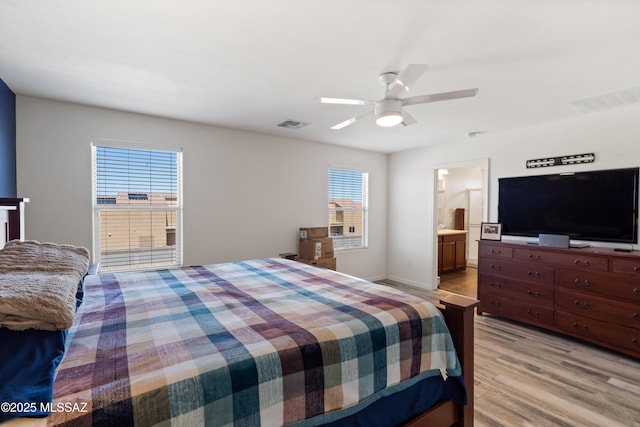 6494 E Brushback Loop, Tucson, AZ 85756 - bedroom with multiple windows, light wood finished floors, a ceiling fan, and connected bathroom
