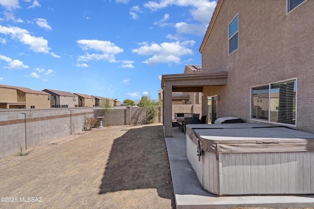 6494 E Brushback Loop, Tucson, AZ 85756 - view of patio / terrace featuring a hot tub, a fenced backyard, and a residential view