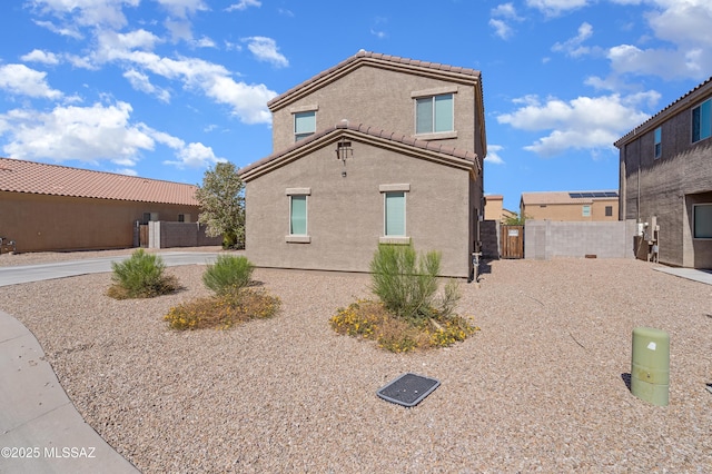 6494 E Brushback Loop, Tucson, AZ 85756 - view of side of property featuring stucco siding, a gate, fence, and a tiled roof