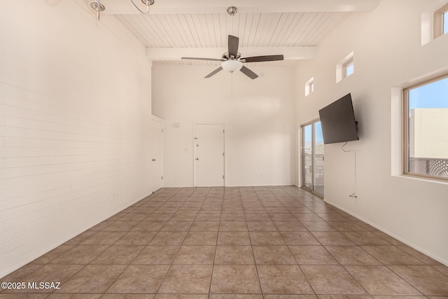 2525 N Alvernon Way Unit F8, Tucson, AZ 85712 - unfurnished living room featuring beamed ceiling, a towering ceiling, a ceiling fan, plenty of natural light, and wooden ceiling