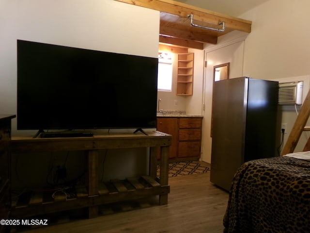 2474 W Victoria Ln, Willcox, AZ 85643 - bedroom with beamed ceiling, freestanding refrigerator, light wood finished floors, and an AC wall unit