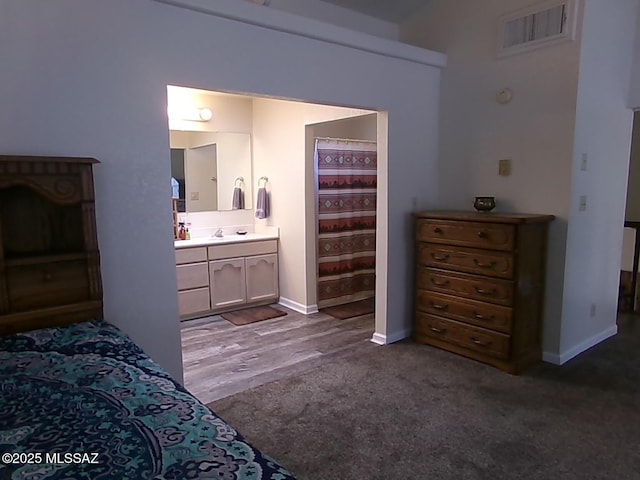 2474 W Victoria Ln, Willcox, AZ 85643 - carpeted bedroom featuring a sink, ensuite bathroom, and baseboards