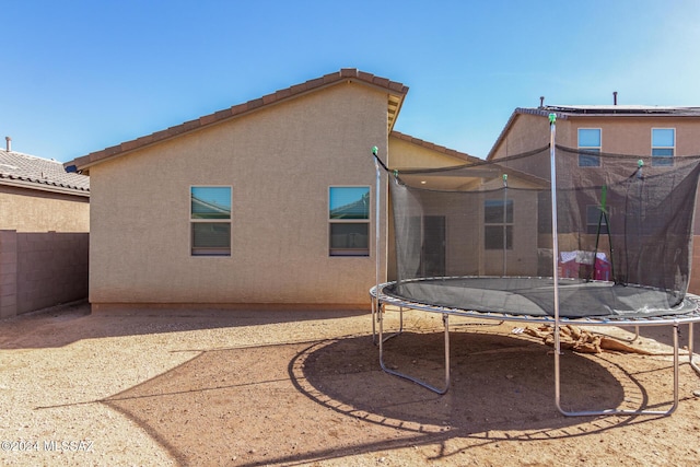 6210 S Open Desert Pl, Tucson, AZ 85706 - rear view of property with a trampoline, stucco siding, a tile roof, and fence