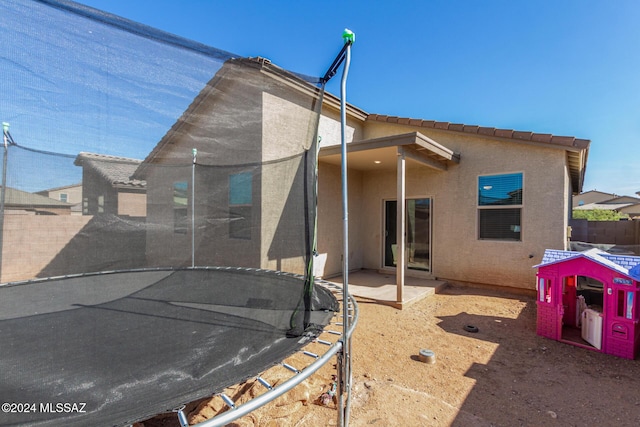 6210 S Open Desert Pl, Tucson, AZ 85706 - rear view of property featuring a trampoline, fence, stucco siding, and a patio