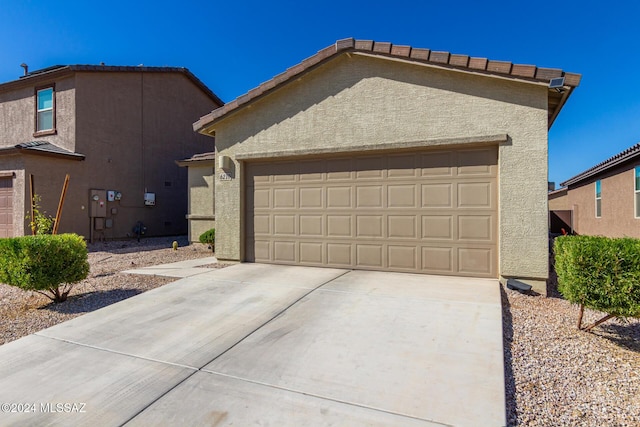 6210 S Open Desert Pl, Tucson, AZ 85706 - view of front facade featuring stucco siding, a garage, and driveway