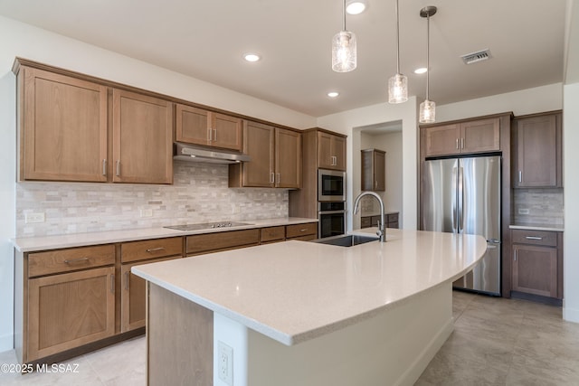 2559 E Wrightson View Dr, Green Valley, AZ 85614 - kitchen featuring appliances with stainless steel finishes, a sink, tasteful backsplash, hanging light fixtures, and a kitchen island with sink