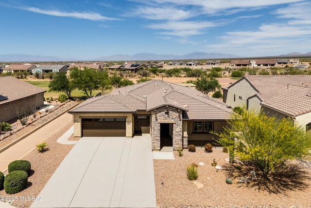 2559 E Wrightson View Dr, Green Valley, AZ 85614 - view of front of house with stone siding, stucco siding, a residential view, an attached garage, and concrete driveway