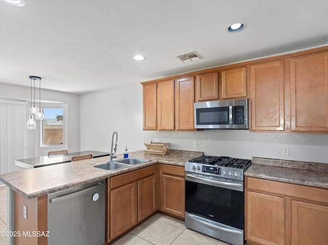 4801 E Canary Grass Dr, Tucson, AZ 85756 - kitchen featuring stainless steel appliances, a sink, a peninsula, light tile patterned floors, and brown cabinets