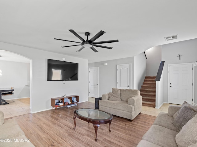 4801 E Canary Grass Dr, Tucson, AZ 85756 - living area featuring arched walkways, stairs, a ceiling fan, baseboards, and light wood finished floors