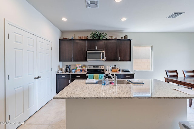12622 N Wildrose Dr, Marana, AZ 85653 - kitchen featuring appliances with stainless steel finishes, a sink, light stone counters, dark brown cabinetry, and recessed lighting