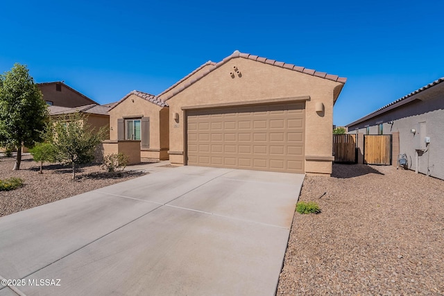 12622 N Wildrose Dr, Marana, AZ 85653 - mediterranean / spanish-style house with an attached garage, driveway, stucco siding, a gate, and a tiled roof