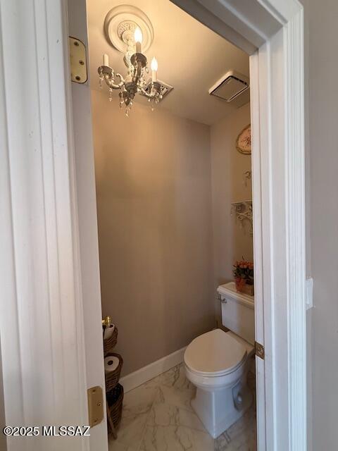7774 E Cleary Way, Tucson, AZ 85715 - bathroom featuring marble look tiles, a chandelier, toilet, and baseboards