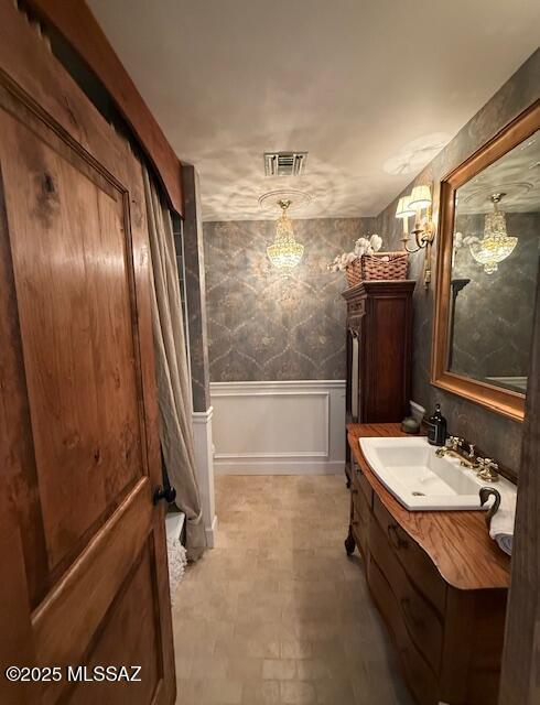 7774 E Cleary Way, Tucson, AZ 85715 - bathroom with vanity, a wainscoted wall, and a decorative wall