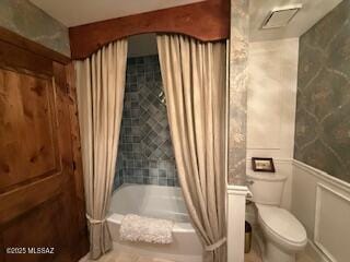 7774 E Cleary Way, Tucson, AZ 85715 - bathroom featuring toilet, shower / bathtub combination with curtain, and wainscoting