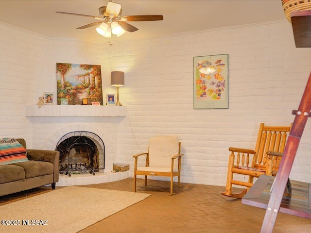 641 W Las Lomitas Rd, Tucson, AZ 85704 - living area with ceiling fan, brick flooring, a fireplace with raised hearth, crown molding, and brick wall