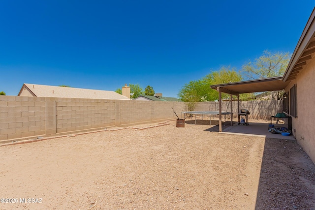 fenced backyard with a trampoline