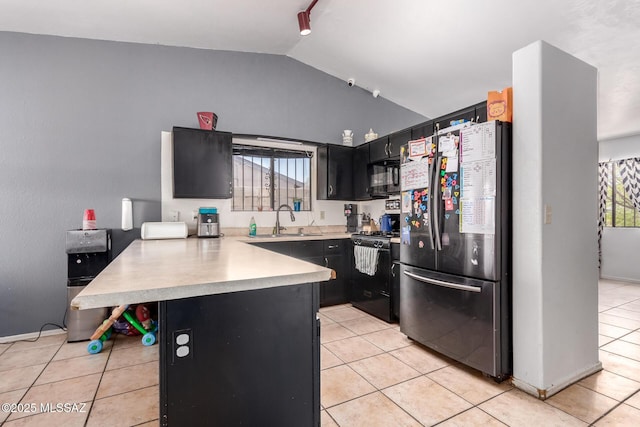 kitchen featuring black appliances, a peninsula, a sink, lofted ceiling, and dark cabinets