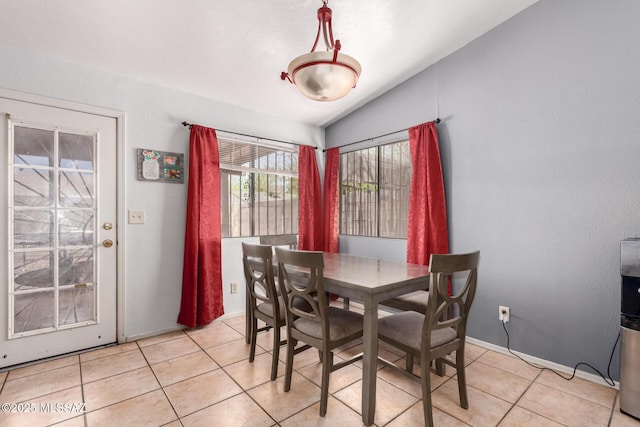 dining space featuring vaulted ceiling and light tile patterned flooring