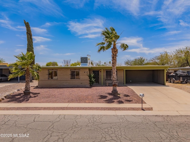 2002 E Pinon Dr, Tucson, AZ 85706 - view of front of property with driveway, brick siding, and a garage