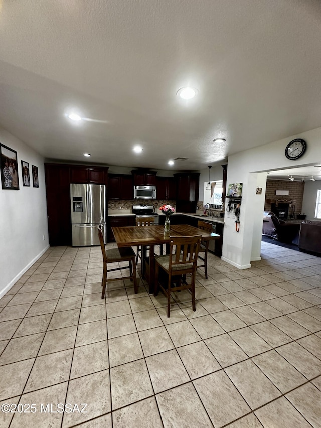 1609 S 12th Ave, Safford, AZ 85546 - dining room with light tile patterned flooring, recessed lighting, baseboards, and a fireplace
