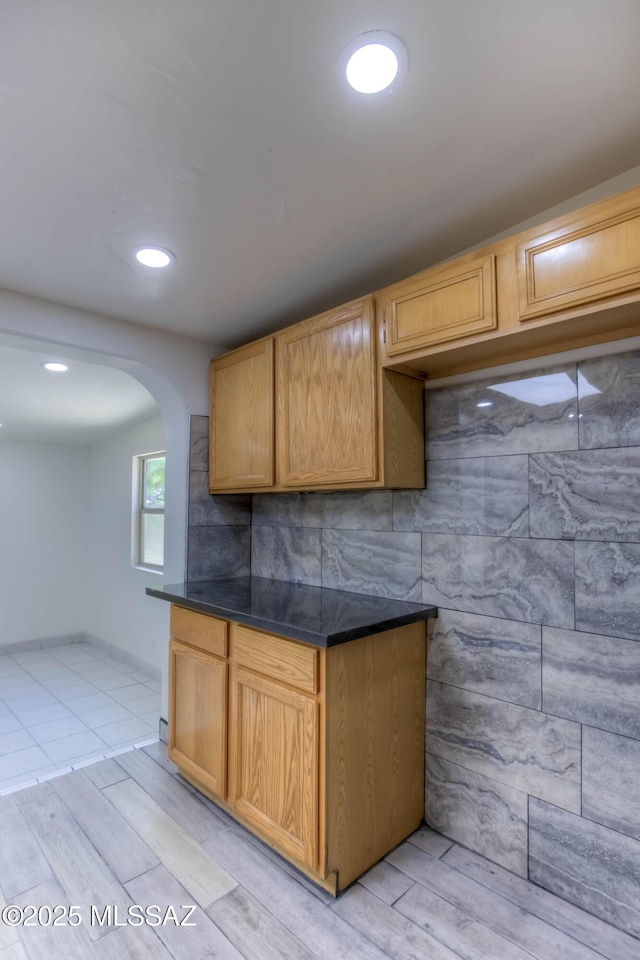 4842 E 27th St, Tucson, AZ 85711 - kitchen with dark countertops, arched walkways, light wood-type flooring, and recessed lighting