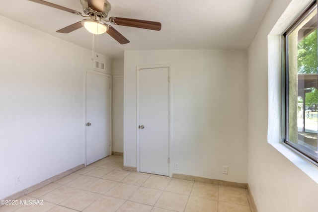 4842 E 27th St, Tucson, AZ 85711 - unfurnished bedroom with light tile patterned floors, a ceiling fan, and baseboards